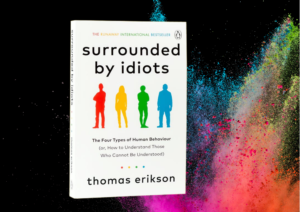 A copy of Thomas Erikson's book Surrounded by Idiots on a colorful background.