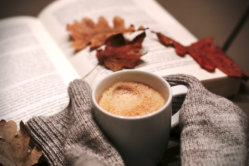 Someone enjoying a book while drinking coffee