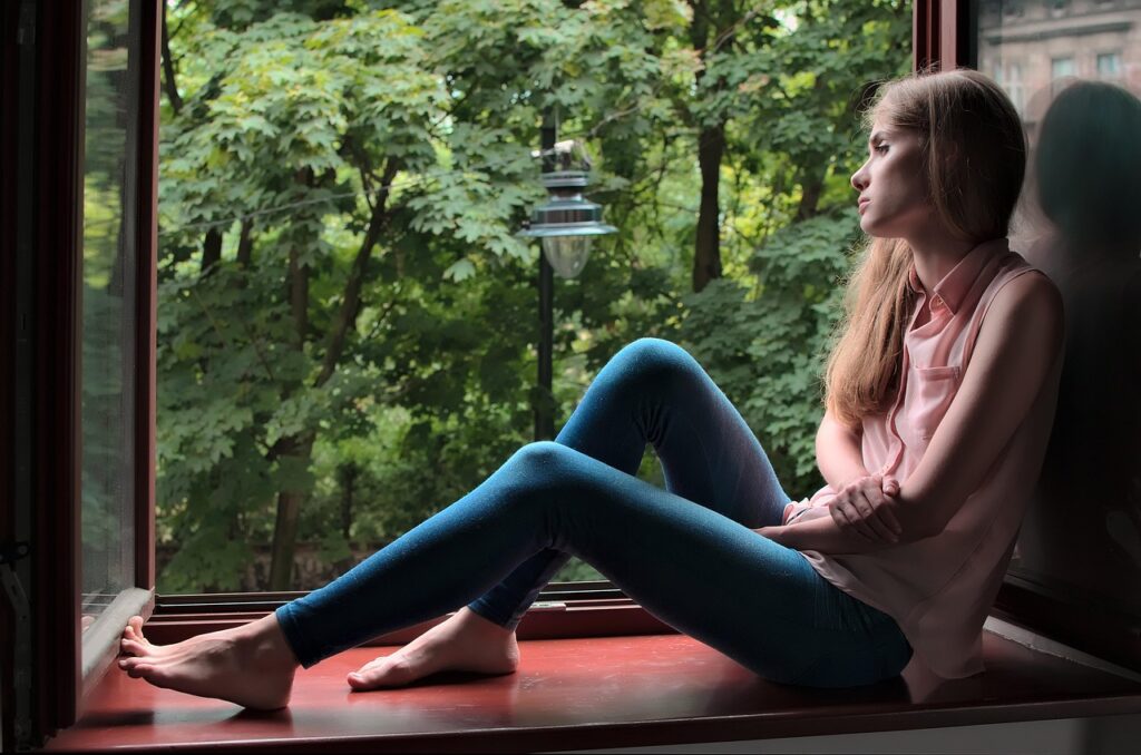 woman, sitting on a window wondering why no one listens to her